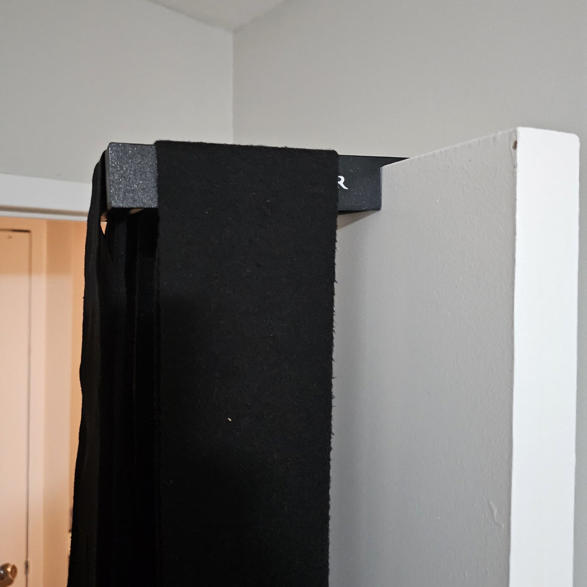 Black Stallion Silver wrap roller hooked over the top of a door with wet black wraps draped over it to dry