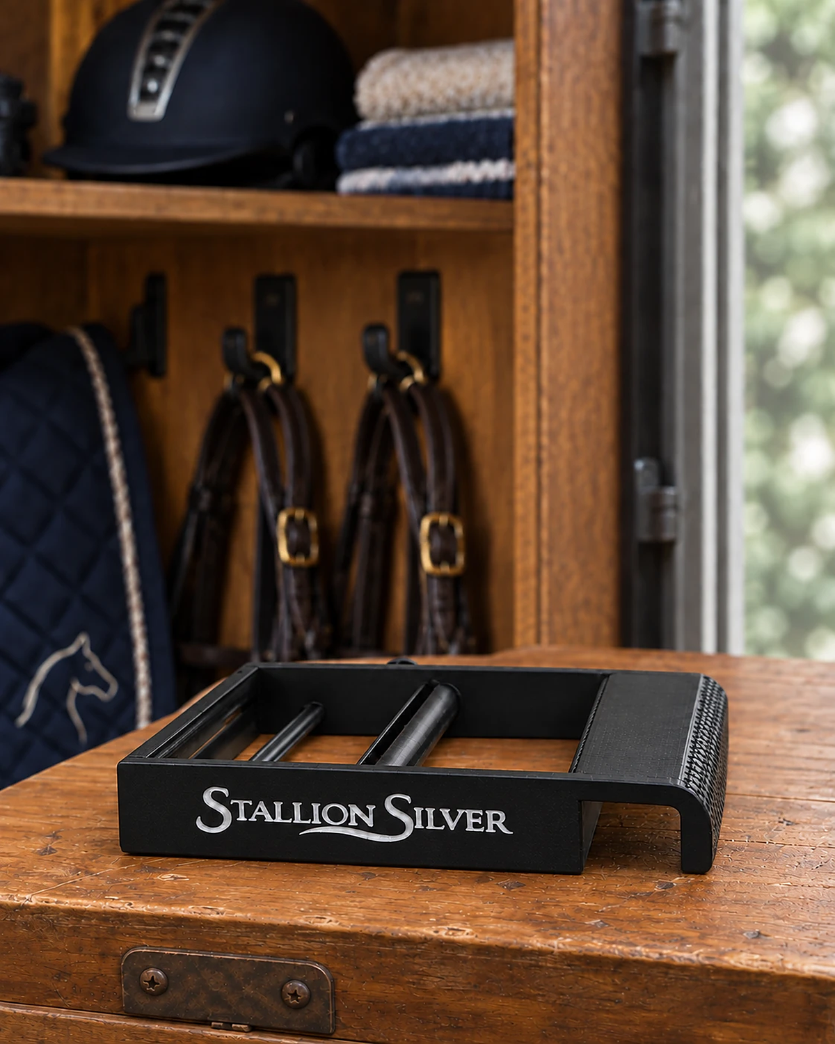 Black Stallion Silver wrap roller on a wooden tack trunk, hook end showing the grip and door slot